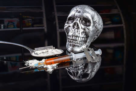 Syringe and spoon with dangerous harmful drugs. Death from drug overdose concept. Spoon with white heroin powder.の写真素材