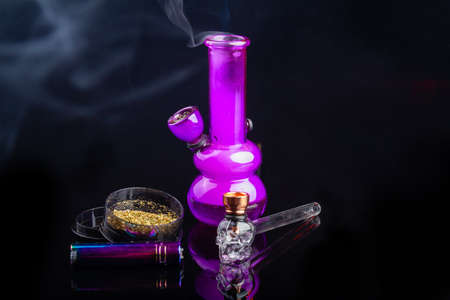 Glass bong with mj weed smoke and glass pipe with lighter. Light drug smoking concept.の写真素材