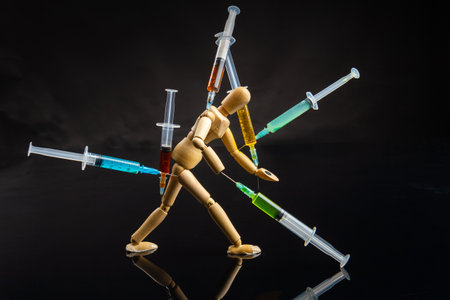 Tiredness from drugs and overdose concept. Wooden mannequin with stuckes syringes. Exhausted walking...