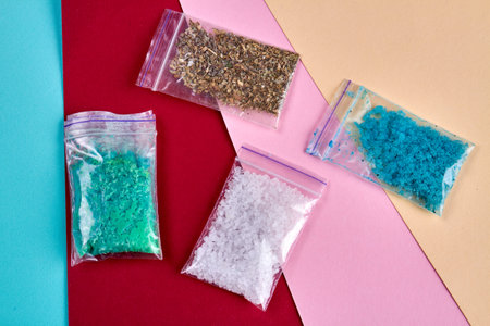 Four packs of multicolored drugs on red and pink background. Top view doses of medicine or drugs.の写真素材