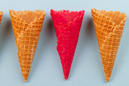 Close up red waffle ice cream cones and ordinary ones. Blue pastel background.の写真素材