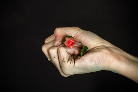 Close up womans hand clenching flowers in a fist. Concept of enviroment spoil.の写真素材
