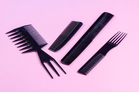 Set of black professional salon barber hair combs. Isolated on pink.の写真素材