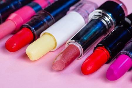 Close up set of various multicolored lipsticks. Isolated on pink.の写真素材