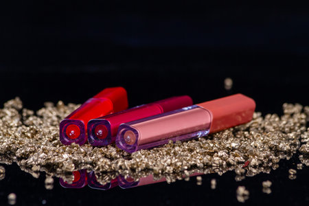 Red lip gloss sticks and golden rocks. Concept of expensive make-up tools.の写真素材