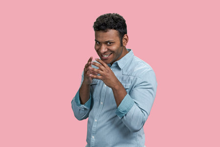 Portrait of a young devious brunette indian man. Cunning tricky face and smirk. Planning an evil trick.の写真素材