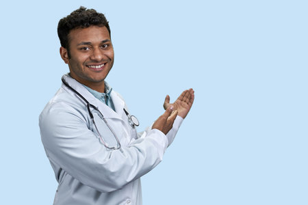 Portrait of male indian doctor showing copy space Isolated on blue background.の写真素材