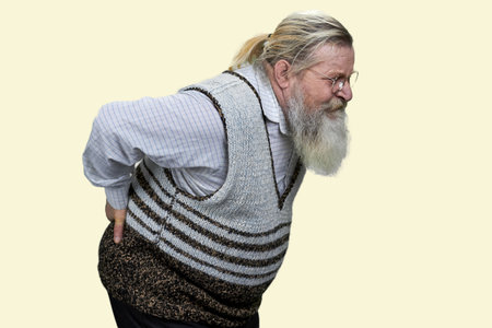 Aged long-bearded man suffering from back pain. Isolated on white.の写真素材