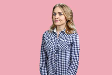 Portrait of young blonde with sceptical facial expression. Isolated on pink background.の写真素材