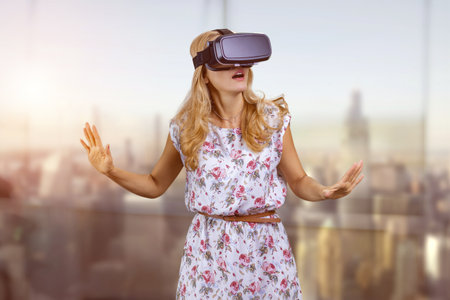 Portrait of blonde woman in VR headset. Abstract blurred background.の写真素材