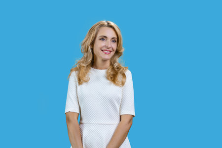 Portrait of a attractive thoughtful blonde mature woman. Isolated on pastel blue.の写真素材