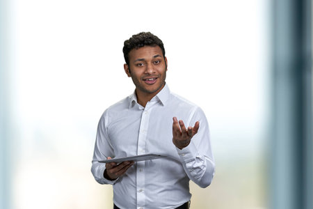 Handsome male business coach giving a lecture using digital tablet pc. Young businessman using computer tablet while giving a presentation.の写真素材