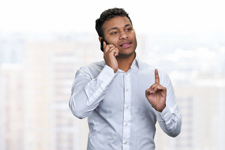 Portrait of confident young businessman talking on mobile phone. People, business, communication and modern technology concept.の写真素材
