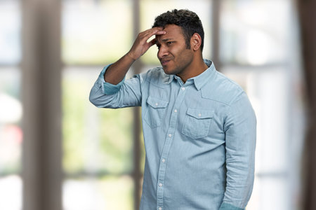Upset frustrated young man suffering from strong headache. Health problem concept.の写真素材