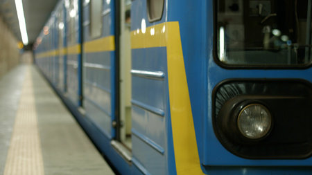 Beautiful modern metro train at the station. A blue-yellow subway train leaves for the next station.
