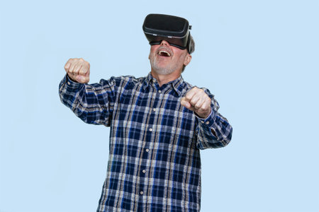 Portrait of elder man driving a virtual imaginary steering wheel. Isolated on blue background.の写真素材