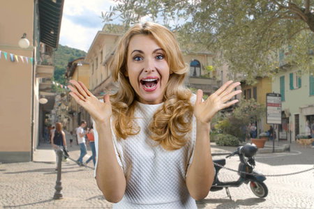 Portrait of surprised excited mature woman with her mouth open. Urban city street in the background.の写真素材