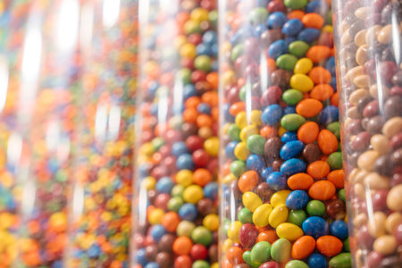 Close-up of chocolate candies in vertical display tubes. A bright and cheerful arrangement of...