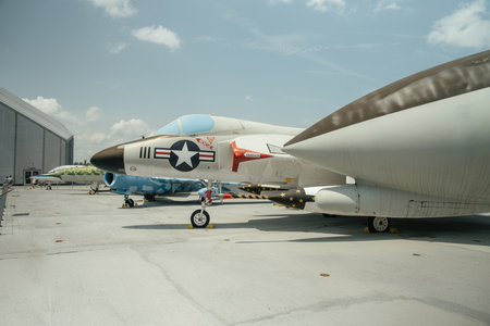 A vintage U.S. military jet is displayed outdoors on a rooftop exhibit. The aircraft features...