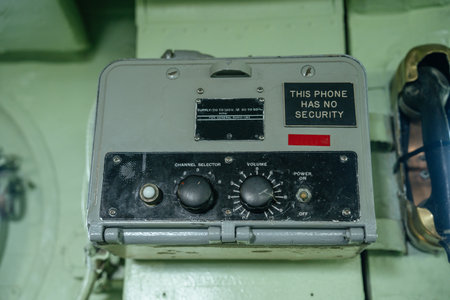 Close-up of a military phone device with a bold label stating This Phone Has No Security. The unit...