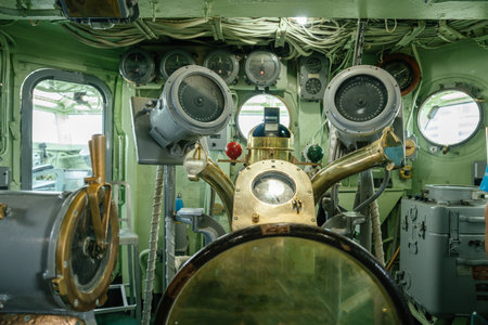 Interior of a historical ship bridge filled with analog navigation instruments and a brass compass....