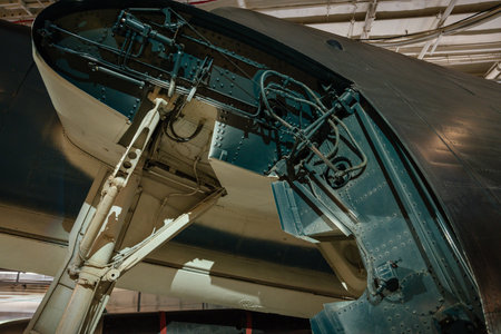 Detailed view of the landing gear and hydraulic systems inside a military aircrafts wheel well. The...