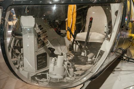 A close-up of a helicopter cockpit interior showing control panels, levers, and flight instruments....