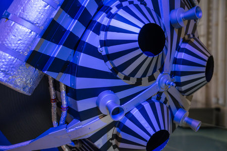 Extreme close-up of a space capsules striped thruster system under dramatic blue lighting. The detailed design features conical nozzles and reflective tubing.の写真素材
