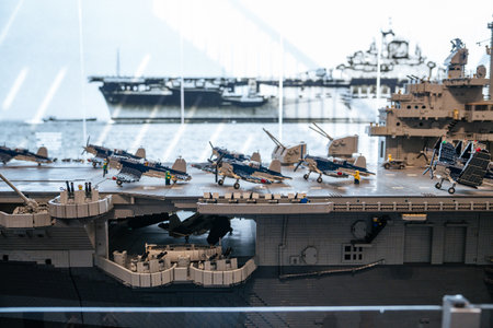 Detailed close-up of a model aircraft carrier deck lined with miniature fighter jets and crew...