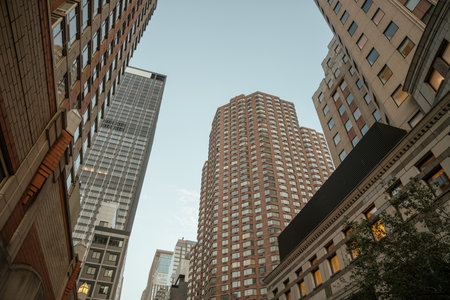 Tall residential and office buildings rise into the sky in a dense urban area. The warm evening...