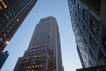 A towering skyscraper is framed by other high-rise buildings in New York City during early evening....