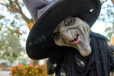 Weathered witch decoration tilts her head with a crooked smile and cracked skin. Halloween yard...