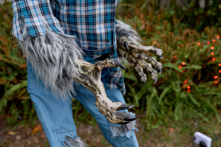Close-up of a werewolfs clawed hands reaching forward with sharp black nails. Hairy gray fur, plaid...