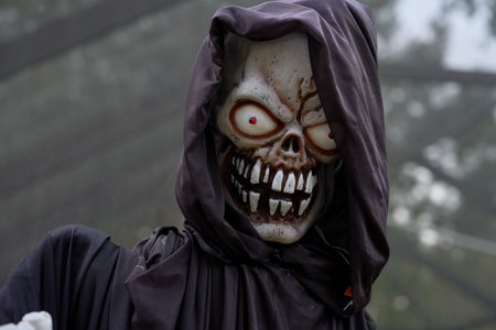 A hooded skeleton reaper stares with red glowing eyes and a wide grin. Black robe, bone details, and...