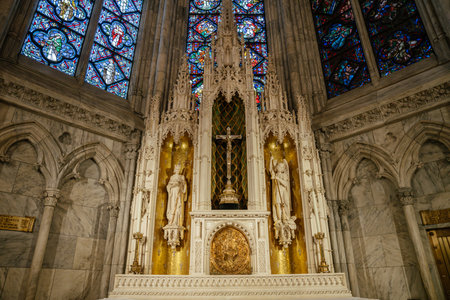 This image showcases a golden Gothic-style altar featuring religious statues, a central crucifix, and shimmering gold mosaic panels. Surrounding stained-glass windows and marble arches enhance the sacred beauty of this ornate chapel interior.の写真素材