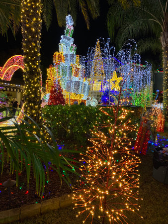 Palm trees and glowing Christmas gifts create a colorful tropical holiday atmosphere. The outdoor display sparkles with lights, joy, and festive energy.の写真素材