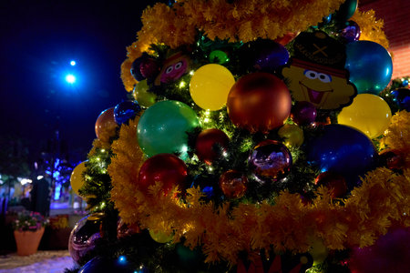 Orlando, Florida, USA - 11.15.2024: Shiny ornaments cluster on a decorated Christmas tree at night. Bright baubles and tinsel glow with holiday lights.のeditorial素材