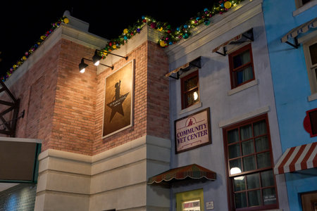 Orlando, Florida, USA - 11.15.2024: Festive garland trims a brick corner above a sign for a community vet center. Lit windows and storefront details create a lively night streetscape.のeditorial素材