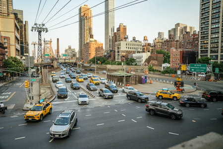New York City, New York, USA - 08.01.2024: Cars and yellow taxis crowd the entrance to the Ed Koch Queensboro Bridge during evening rush hour. Tall buildings and directional signs frame this bustling city scene in Manhattan.のeditorial素材