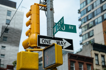 Street signs for West 23 Street and 10 Avenue are displayed above a one way traffic sign in New York...