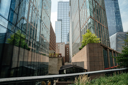 Modern glass and steel skyscrapers rising above West Chelsea in New York City. Contemporary architecture reflects the skyline and urban development of Manhattan.の写真素材