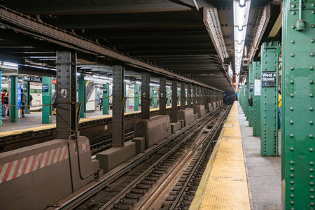 A long perspective view of subway tracks at West 4 Street station in Manhattan. The underground New...