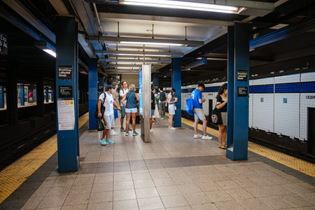 New York City, New York, USA - 08.03.2024: Group of commuters waiting on the platform at Broadway...