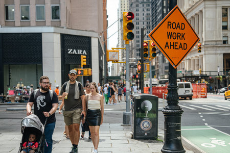 New York City, New York, USA - 08.03.2024: Close perspective of a road work ahead sign near traffic...