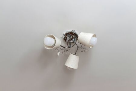 Beautiful chandelier on the ceiling in the room, isolated, three lamps, silverの写真素材