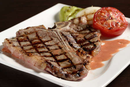 Grilled marbled beef T-bone steak close-up with grilled vegetables. Photos for restaurant and cafe menusの写真素材