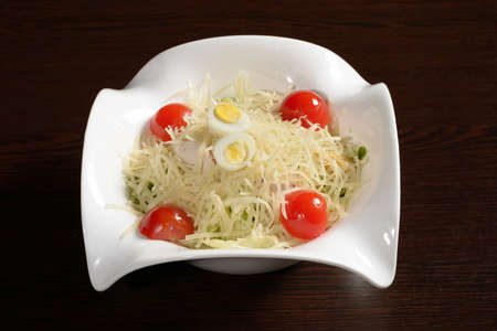 Vegetable salad with chicken sprinkled with cheese garnished with cherry tomatoes and quail eggs. Photos for restaurant and cafe menusの写真素材
