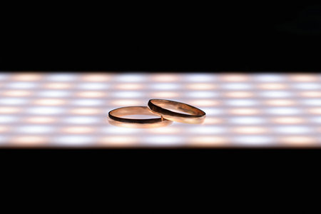 Wedding rings close-up, with LED lighting and dark background