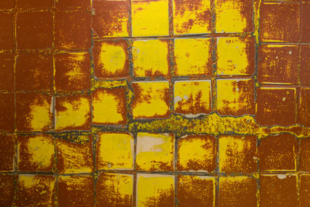 Texture background of old tiles on the floor with scuffs and stains, abstractly painted with brown and yellow paintの写真素材
