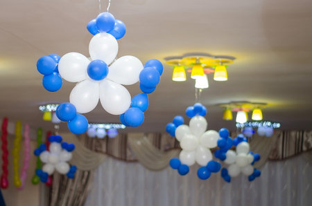 Snowflakes from white and blue balloons adorn the ceiling in the festive hallの写真素材